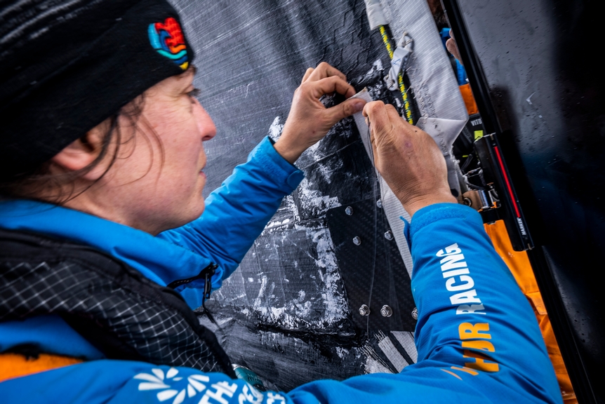 The Ocean Race 2022-23 - 19 March 2023, Leg 3, Day 21 onboard 11th Hour Racing Team. Justine Mettraux pushing through a needle for final hand-stitched reinforcement on the mainsail repair.
